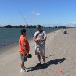 fish sampler interviewing fisherman on river bank