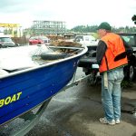 Person standing next to boat interviewing second person standing to same boat