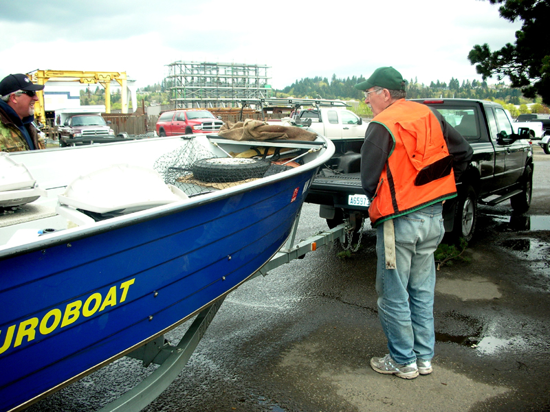 Person standing next to boat interviewing second person standing to same boat