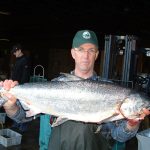 Person holding fish up in hatchery facility